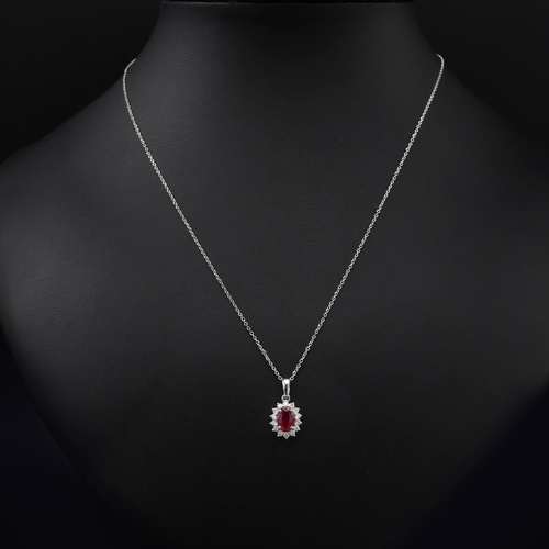 138 - 18ct white gold oval ruby and RBC diamond cluster pendant on an 18ct white gold chain, boxed. Ruby 0... 