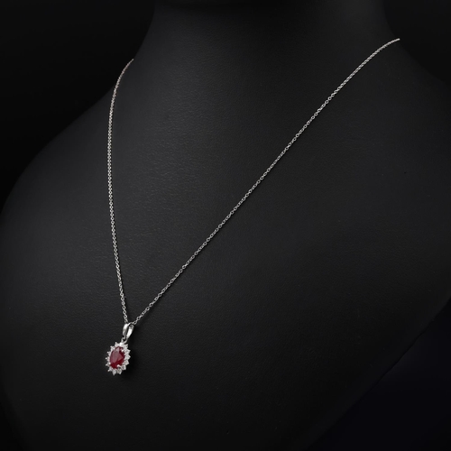 138 - 18ct white gold oval ruby and RBC diamond cluster pendant on an 18ct white gold chain, boxed. Ruby 0... 