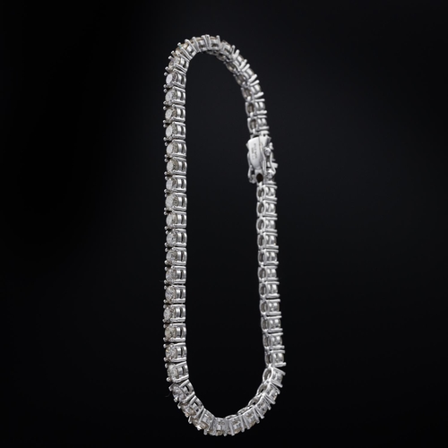 140 - A PLATINUM DIAMOND SET TENNIS BRACELET, set with approximately 50 round brilliant cut diamonds, with... 