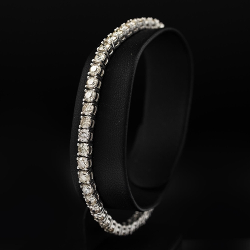 140 - A PLATINUM DIAMOND SET TENNIS BRACELET, set with approximately 50 round brilliant cut diamonds, with... 