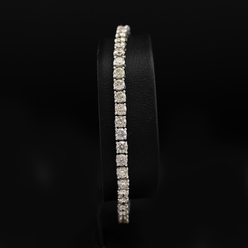 140 - A PLATINUM DIAMOND SET TENNIS BRACELET, set with approximately 50 round brilliant cut diamonds, with... 