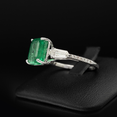 144 - AN 18CT WHITE GOLD EMERALD AND DIAMOND RING, set with an octagonal cut central emerald, flanked by t... 