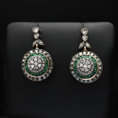 91 - A PAIR OF EMERALD AND DIAMOND PENDANT EARRINGS, rose yellow metal backs, each with a cluster of diam... 