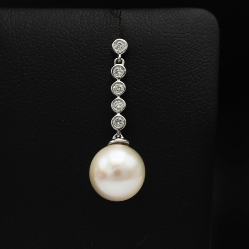 92 - A PAIR OF 9CT WHITE GOLD CULTURED PEARL DROP EARRINGS, each with diamond set bales, diamonds with a ... 