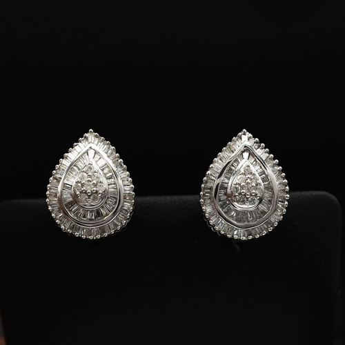 93 - A PAIR OF DIAMOND ENCRUSTED 9CT WHITE GOLD EARRINGS, of tear drop form, each set with a cluster of e... 