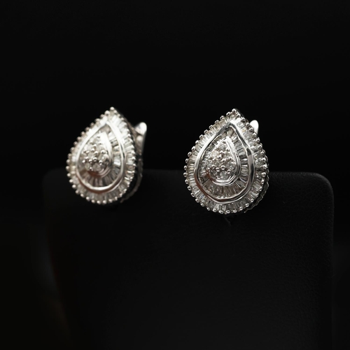 93 - A PAIR OF DIAMOND ENCRUSTED 9CT WHITE GOLD EARRINGS, of tear drop form, each set with a cluster of e... 