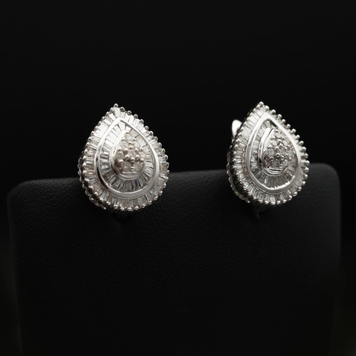 93 - A PAIR OF DIAMOND ENCRUSTED 9CT WHITE GOLD EARRINGS, of tear drop form, each set with a cluster of e... 