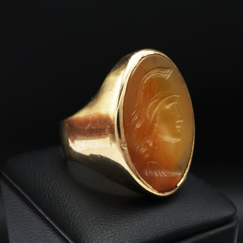 95 - A 9CT GOLD SIGNET RING, set with a carnelian intaglio depicting the profile of a warrior, open backe... 