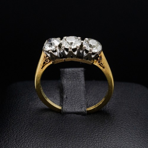 63 - AN 18CT GOLD DIAMOND TRILOGY RING, with three claw set round brilliant diamonds, each of approximate... 