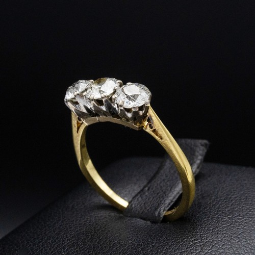 63 - AN 18CT GOLD DIAMOND TRILOGY RING, with three claw set round brilliant diamonds, each of approximate... 