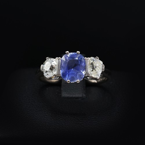 100 - AN 18CT WHITE GOLD CEYLON SAPPHIRE AND DIAMOND TRILOGY RING, the central mixed cut sapphire of appro... 