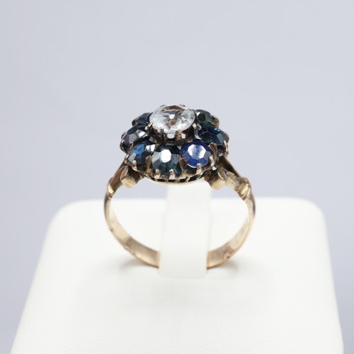 117 - A VICTORIAN YELLOW METAL WHITE AND BLUE SAPPHIRE DRESS RING, the central stone surrounded by eight m... 