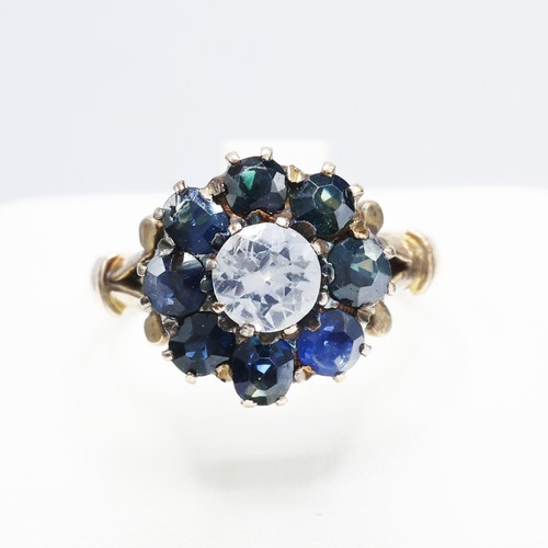 117 - A VICTORIAN YELLOW METAL WHITE AND BLUE SAPPHIRE DRESS RING, the central stone surrounded by eight m... 