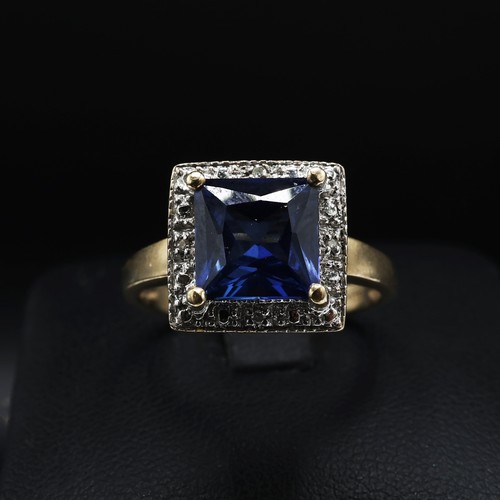 69 - A 9CT GOLD SAPPHIRE AND DIAMOND SET DRESS RING, the central square cut sapphire with a marcasite sur... 