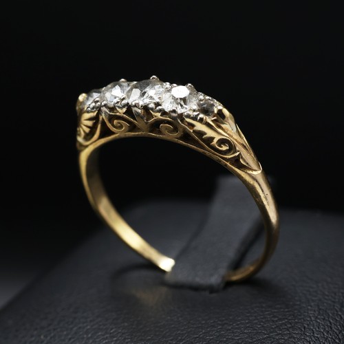 109 - A YELLOW METAL FIVE STONE DIAMOND DRESS RING, set with five graduated brilliant cut diamonds with a ... 