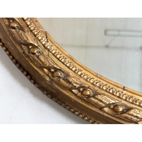 547 - WALL MIRROR, 19th century giltwood and gesso with oval beaded frame with foliate crest and base, 81c... 