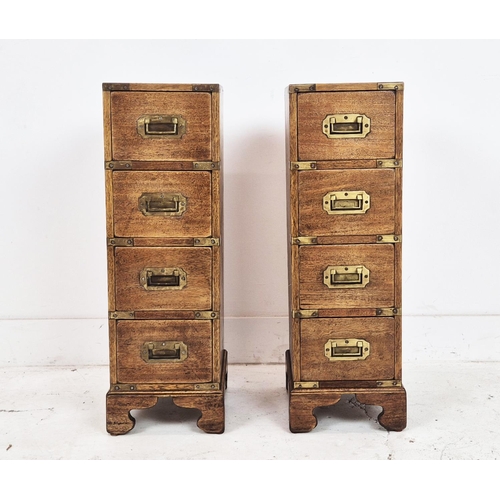 590 - CAMPAIGN STYLE BEDSIDE CHESTS, a pair, mahogany and brass bound of narrow proportions, with four dra... 