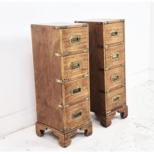 590 - CAMPAIGN STYLE BEDSIDE CHESTS, a pair, mahogany and brass bound of narrow proportions, with four dra... 