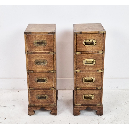 590 - CAMPAIGN STYLE BEDSIDE CHESTS, a pair, mahogany and brass bound of narrow proportions, with four dra... 