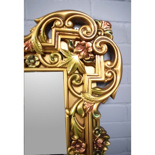 260 - LARGE GILT FRAMED WALL MIRROR WITH FLORAL FRAME. 128cm H x 168cm W.