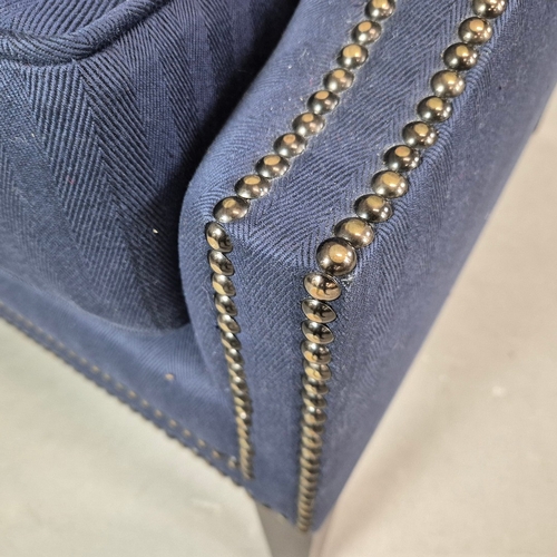 310 - WINGBACK CHAIR AND FOOTSTOOL (2). in blue herringbone fabric 76cm w x 103cm t and a small footstool ... 