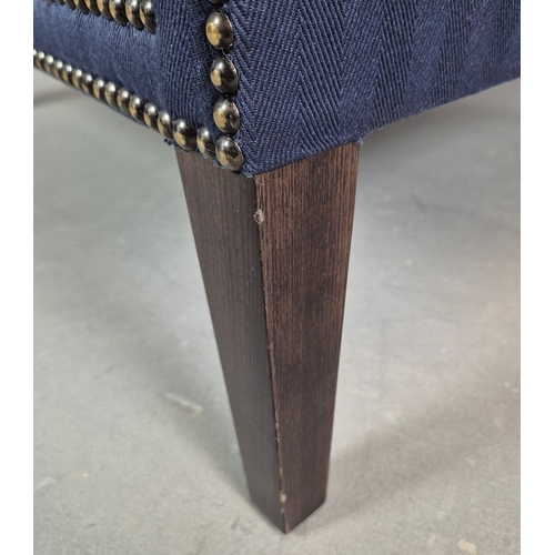 310 - WINGBACK CHAIR AND FOOTSTOOL (2). in blue herringbone fabric 76cm w x 103cm t and a small footstool ... 