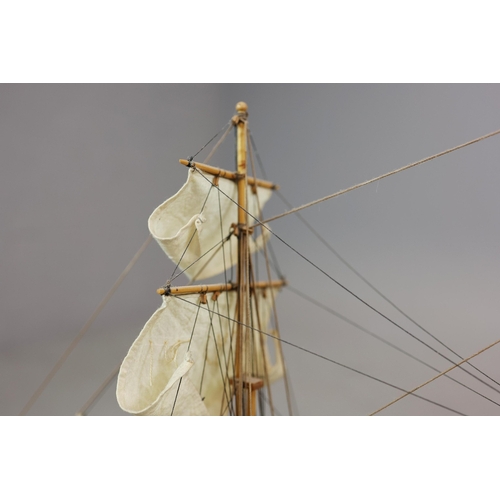 349 - MODEL OF A SQUARE RIGGED SHIP. on a small stand, plaque reads 