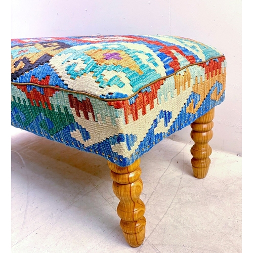 23 - HEARTH STOOL WITH KILIM UPHOLSTERY ON TURNED SUPPORTS. 52cm H x 123cm W x 50cm D.