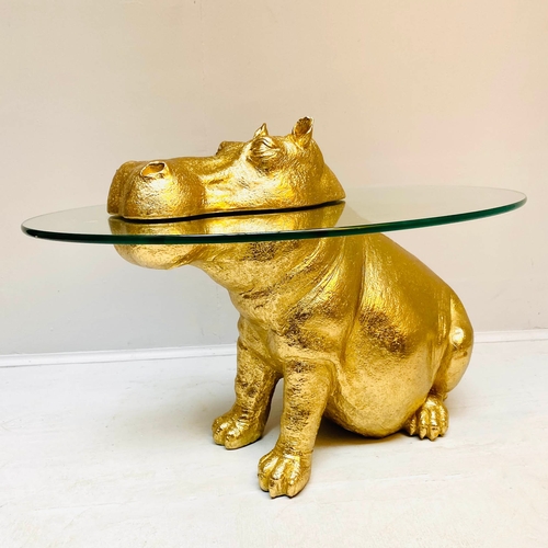 66 - HIPPO LOW TABLE IN A GILT FINISH WITH GLASS TOP. 65cm H x 120cm W x 50cm D.