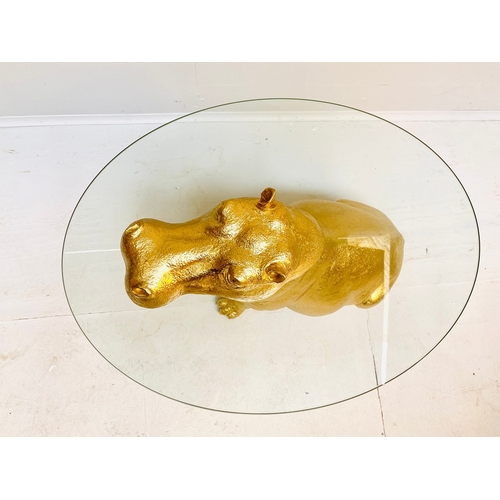 66 - HIPPO LOW TABLE IN A GILT FINISH WITH GLASS TOP. 65cm H x 120cm W x 50cm D.