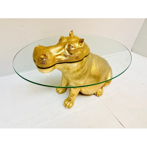66 - HIPPO LOW TABLE IN A GILT FINISH WITH GLASS TOP. 65cm H x 120cm W x 50cm D.