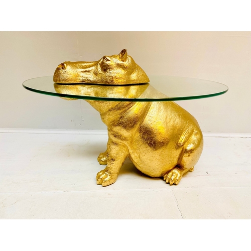 66 - HIPPO LOW TABLE IN A GILT FINISH WITH GLASS TOP. 65cm H x 120cm W x 50cm D.