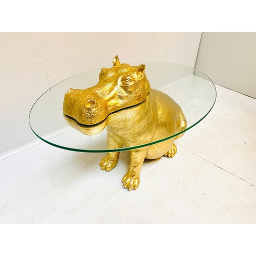 66 - HIPPO LOW TABLE IN A GILT FINISH WITH GLASS TOP. 65cm H x 120cm W x 50cm D.