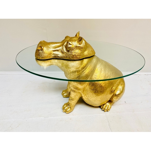 66 - HIPPO LOW TABLE IN A GILT FINISH WITH GLASS TOP. 65cm H x 120cm W x 50cm D.