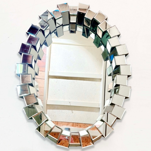 83 - CONTEMPORARY OVAL WALL MIRROR WITH SEGMENTED MIRRORED FRAME. 80cm H x 40cm W.