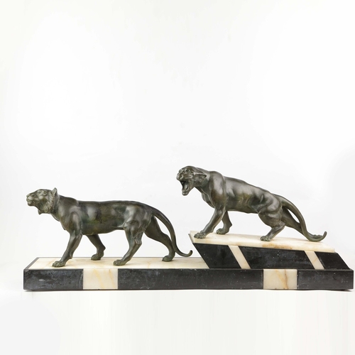 5 - A FRENCH ART DECO LION AND LIONESS SCULPTURE. in spelter on stepped black and white marble base. 85c... 