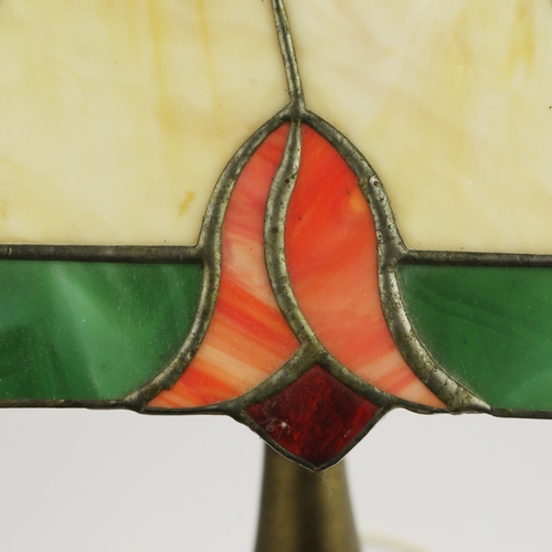 131 - TIFFANY STYLE TABLE LAMP. fitted with a four sided shade in cream and green, raised on a brass lamp ... 