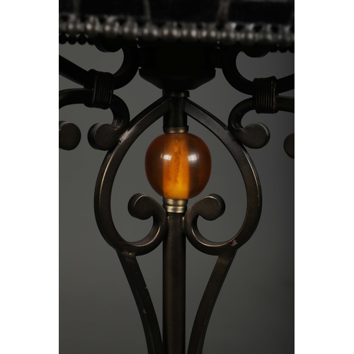 132 - TIFFANY STYLE FLOOR LAMP. the glass shade in a symmetrical stylised foliage design, raised on a scro... 