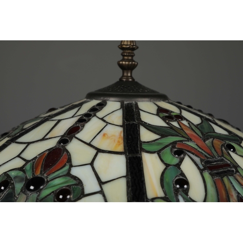 132 - TIFFANY STYLE FLOOR LAMP. the glass shade in a symmetrical stylised foliage design, raised on a scro... 