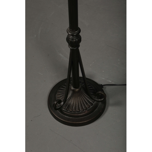 132 - TIFFANY STYLE FLOOR LAMP. the glass shade in a symmetrical stylised foliage design, raised on a scro... 