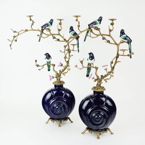 138 - CANDELABRA, A PAIR. in the form of birds amongst trees, shell form bases, ceramic and gilt metal, 65... 