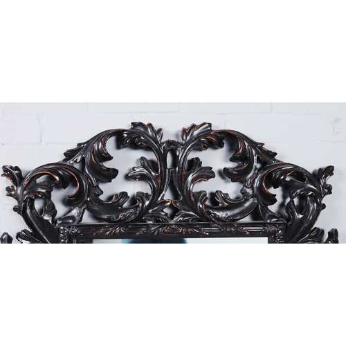 182 - A ROCOCO STYLE BLACK STAINED WALL MIRROR. having an acanthus carved frame, 116cm high, 83cm wide.