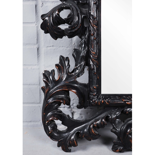 182 - A ROCOCO STYLE BLACK STAINED WALL MIRROR. having an acanthus carved frame, 116cm high, 83cm wide.