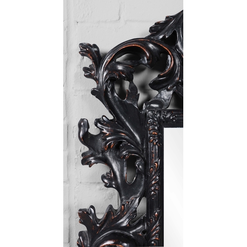 182 - A ROCOCO STYLE BLACK STAINED WALL MIRROR. having an acanthus carved frame, 116cm high, 83cm wide.