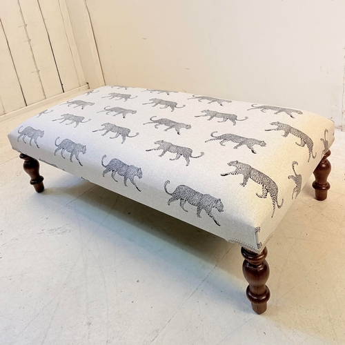 192 - LOW FOOTSTOOL IN LEOPARD PRINT UPHOLSTERY ON TURNED SUPPORTS. 38cm H x 100cm W x 50cm D.