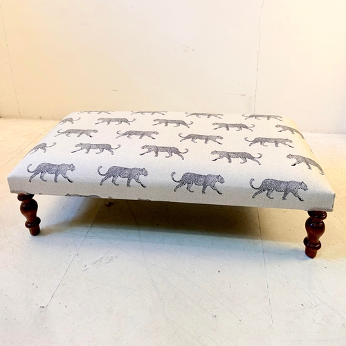 192 - LOW FOOTSTOOL IN LEOPARD PRINT UPHOLSTERY ON TURNED SUPPORTS. 38cm H x 100cm W x 50cm D.