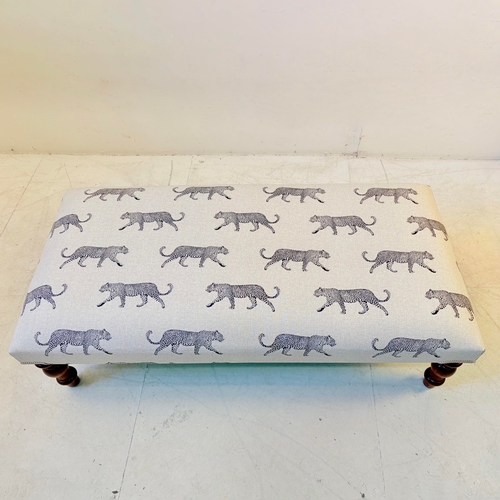 192 - LOW FOOTSTOOL IN LEOPARD PRINT UPHOLSTERY ON TURNED SUPPORTS. 38cm H x 100cm W x 50cm D.