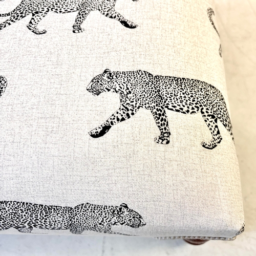 192 - LOW FOOTSTOOL IN LEOPARD PRINT UPHOLSTERY ON TURNED SUPPORTS. 38cm H x 100cm W x 50cm D.