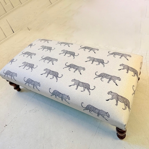 192 - LOW FOOTSTOOL IN LEOPARD PRINT UPHOLSTERY ON TURNED SUPPORTS. 38cm H x 100cm W x 50cm D.