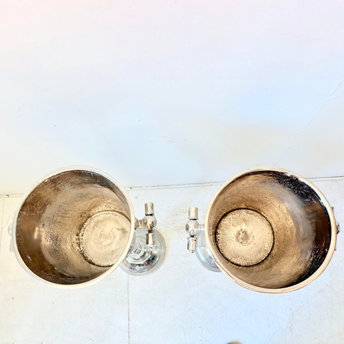 213 - PAIR OF POLISHED METAL CHAMPAGNE BUCKETS ON STANDS WITH HANDLES. 77cm H x 24cm W x 30cm D.
